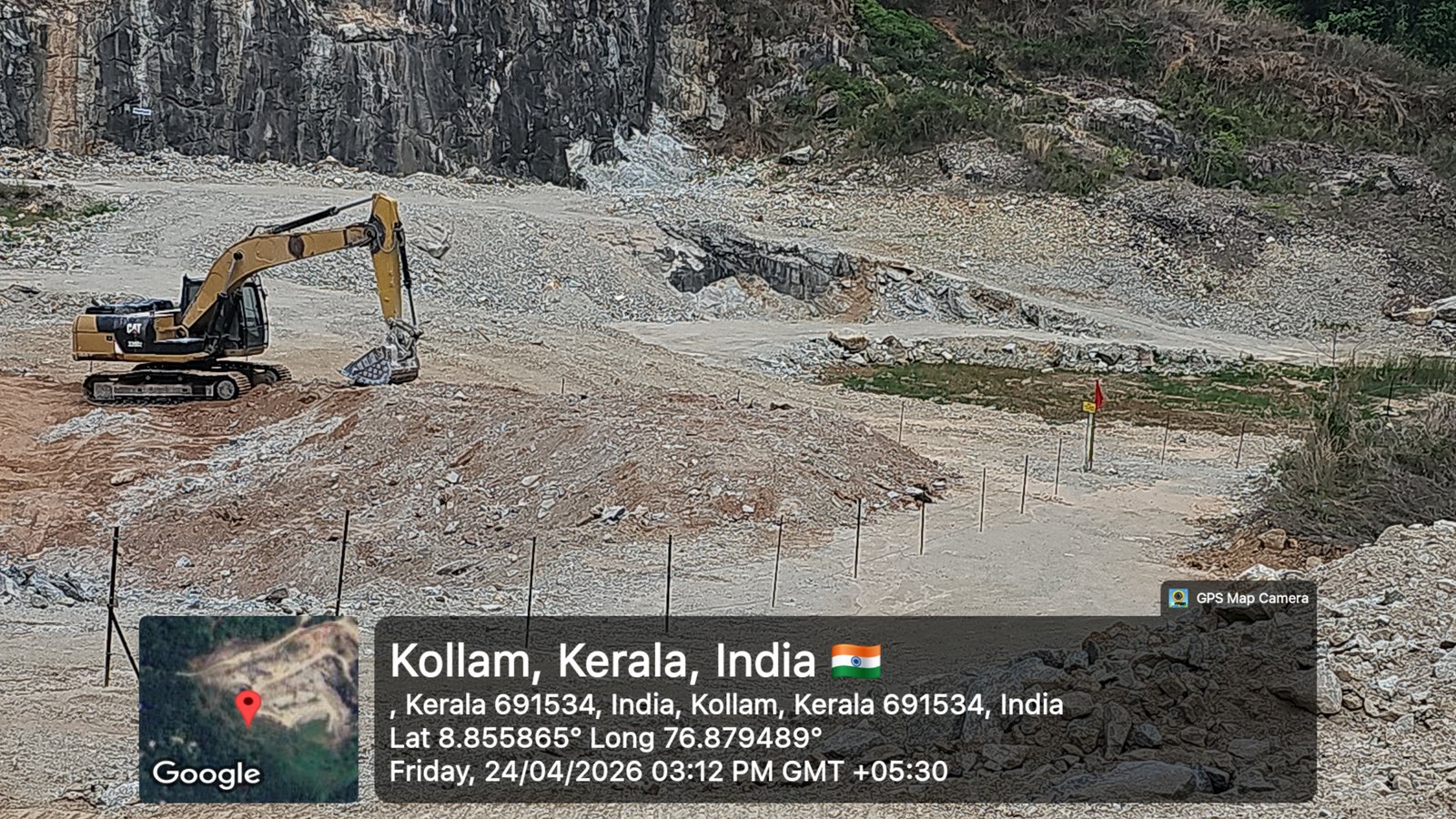 Yellow CAT crawler excavator actively sorting extracted granite blocks on quarry floor